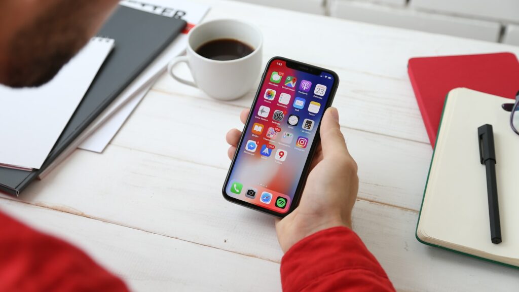 스페이스 그레이 iPhone X를 들고 있는 사람